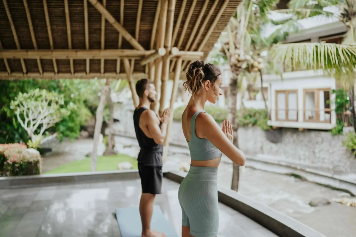 Guests practicing yoga at Harsono Boutique Resort Bali riverside bamboo pavilion