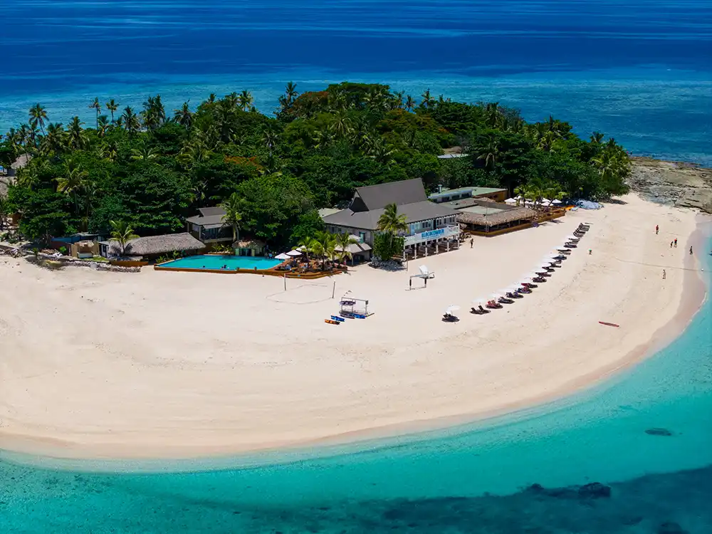 Aerial view of Beachcomber Island Resort in the Mamanuca Islands showing shoreline layout and surrounding coral reef.