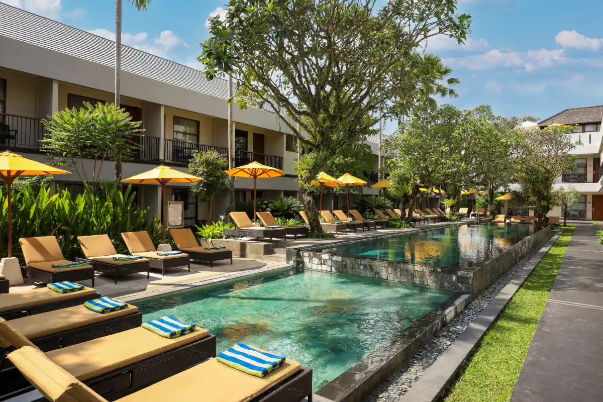 Main outdoor swimming pool, sun loungers, and tropical garden at Amadea Resort & Villas Seminyak