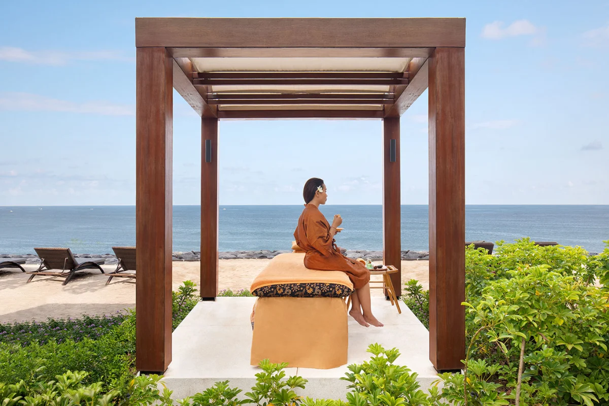 Oceanfront outdoor spa cabana with massage bed on the private beach of Novotel Bali Benoa.