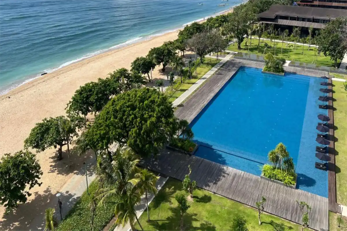 Outdoor swimming pool and sunbed deck area beachfront at The Meru Sanur Bali