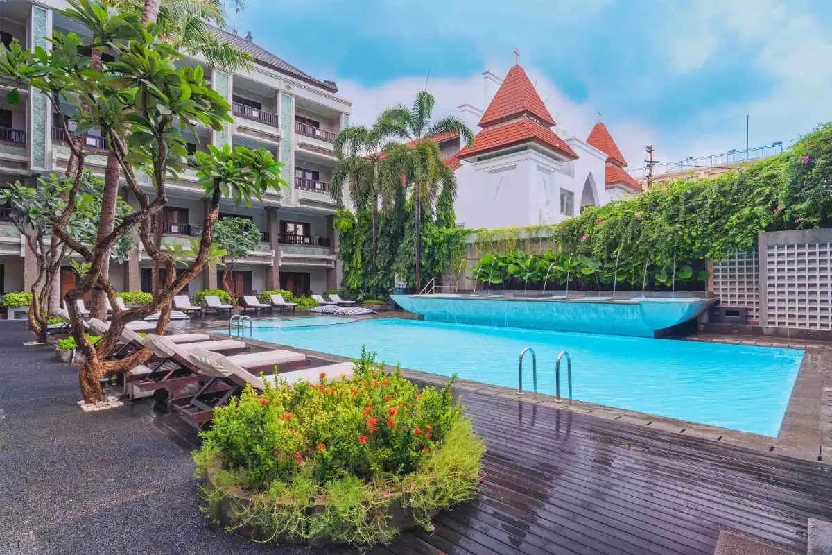 The Vira Bali Boutique Hotel & Suite outdoor swimming pool with sun loungers and tropical garden