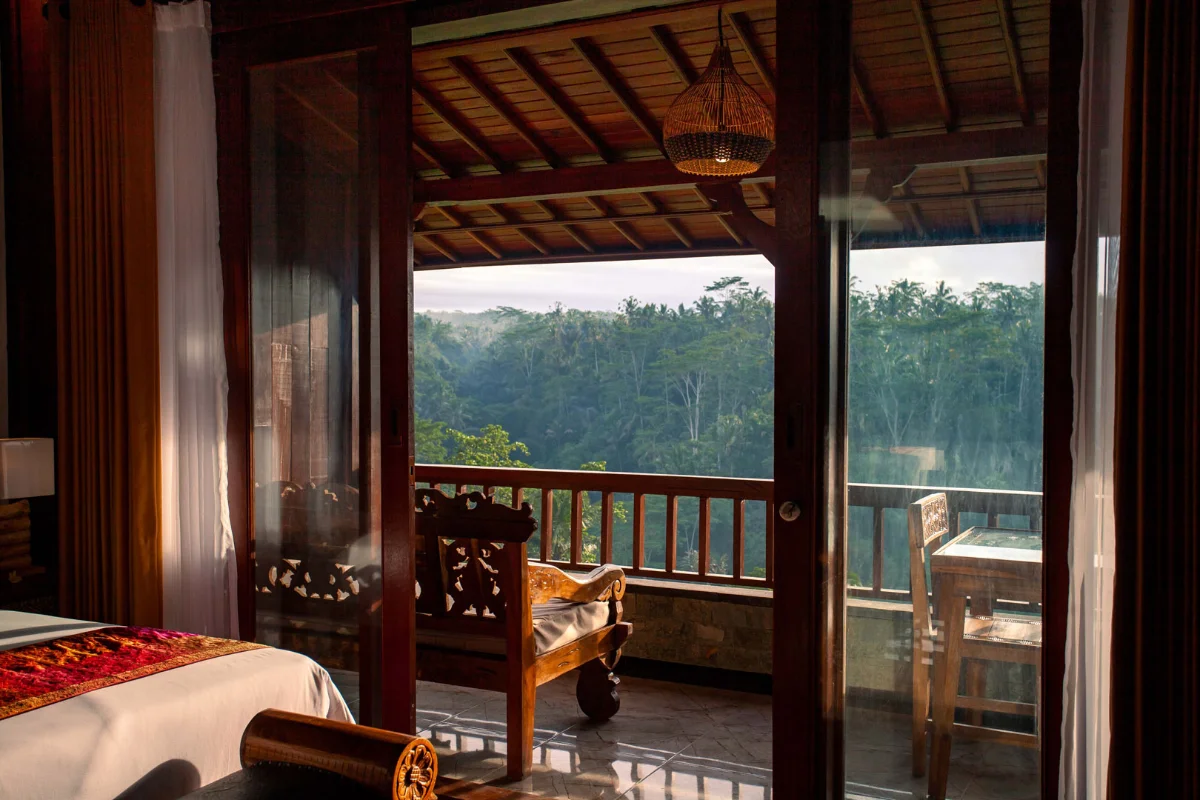 Balcony of a room at Campuhan Sebatu Resort in Bali, overlooking a lush jungle.
