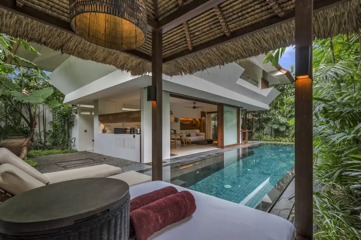 Private swimming pool, sunbeds, and tropical garden outdoor area at Bisma Eight Ubud villa.