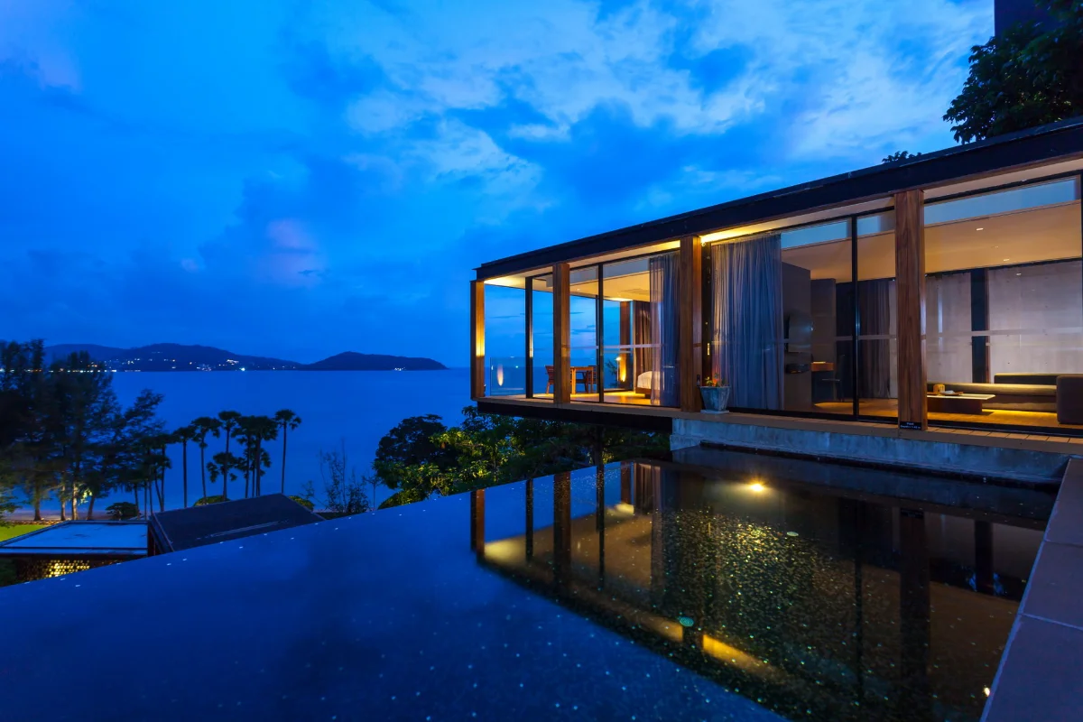 Oceanview infinity pool and glass-walled cantilever villa unit at The Naka Phuket resort.