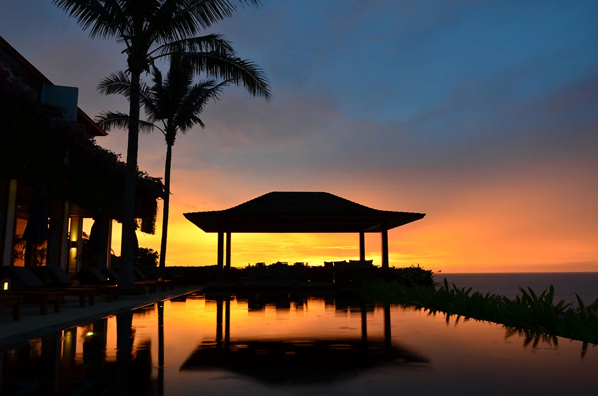 Sunset view over the infinity pool and traditional pavilion at Andara Resort and Villas in Phuket.