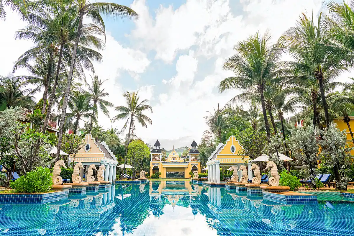 Main outdoor swimming pool surrounded by seahorse statues and palm trees at Phuket Graceland Resort and Spa.