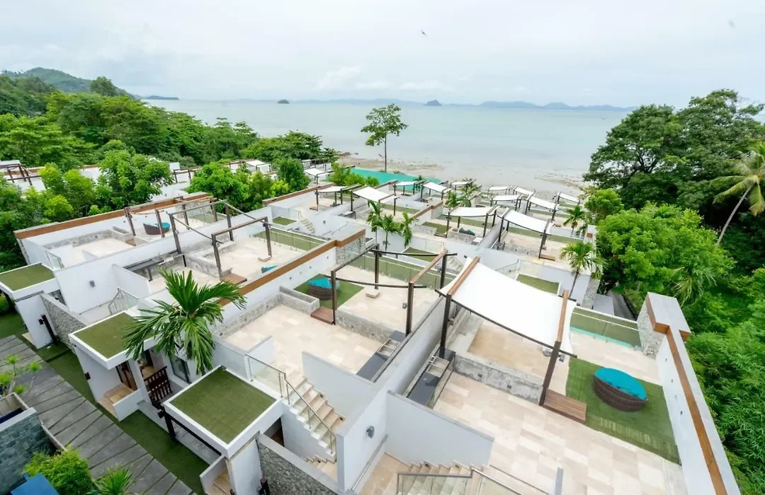 Aerial overview of oceanfront villa suites with private rooftop terraces and outdoor pools at The Nchantra Pool Suite Phuket on Koh Sirey beach.